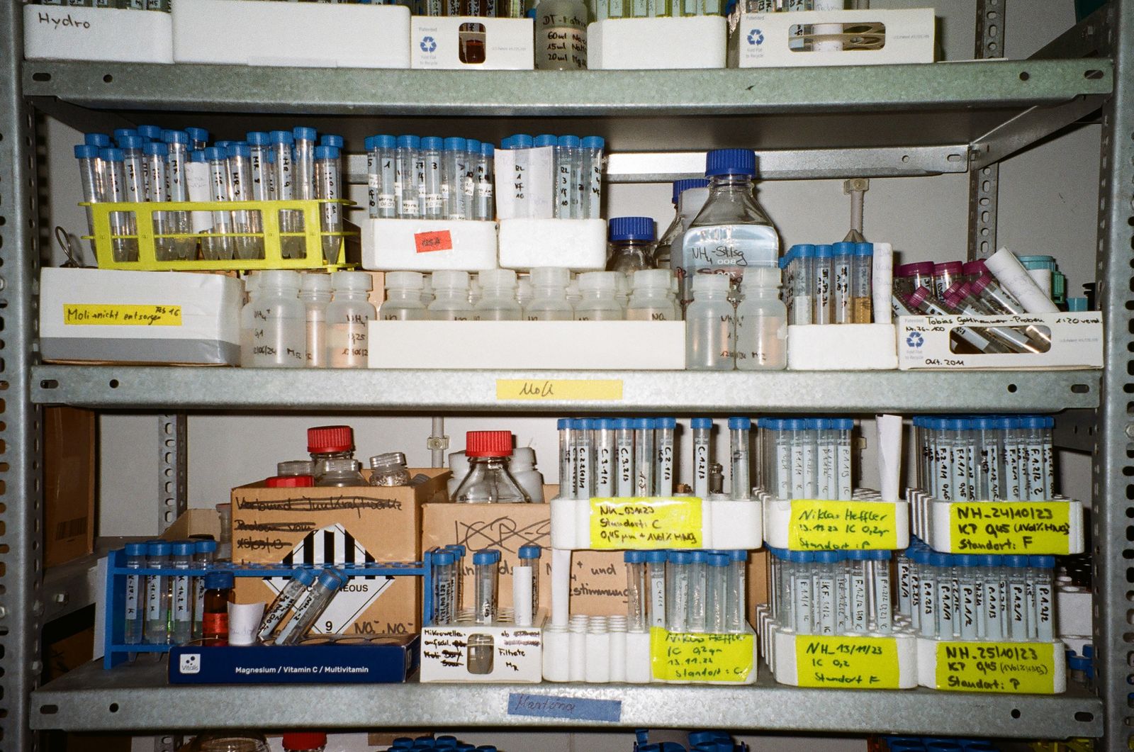 Organised laboratory shelves lined with vials and sample bottles.