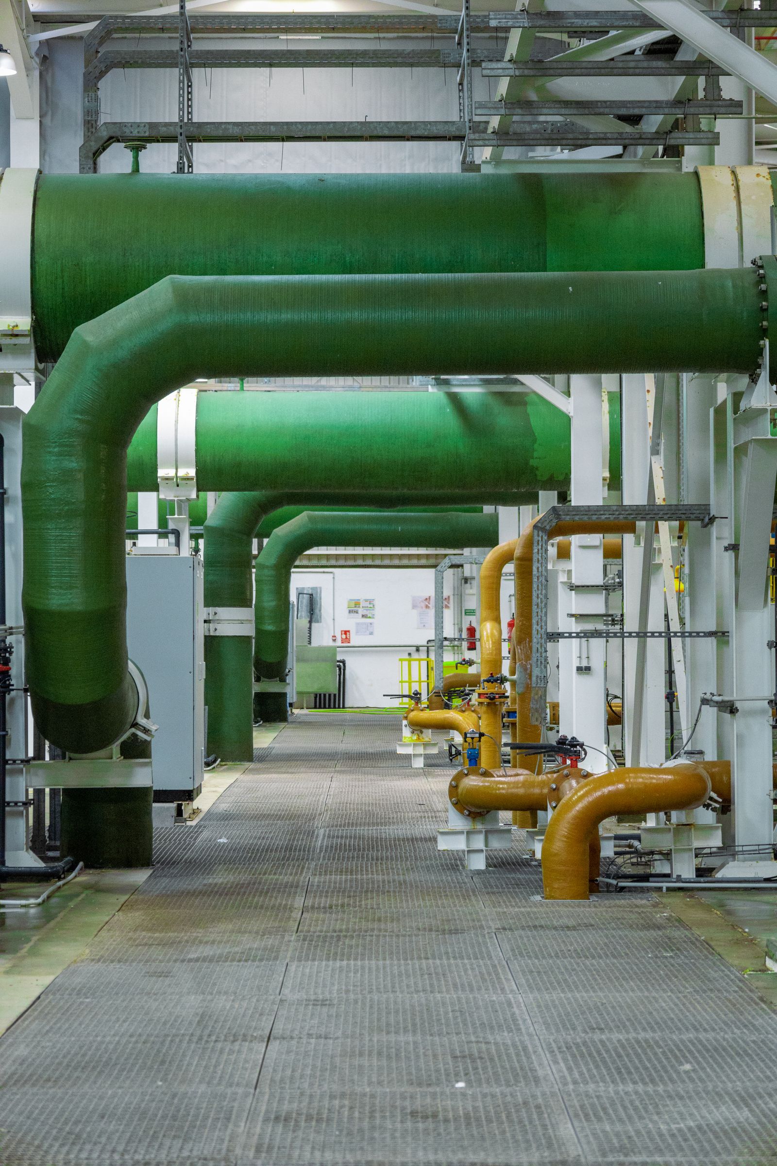 Large pipes and structural framing inside an industrial building.