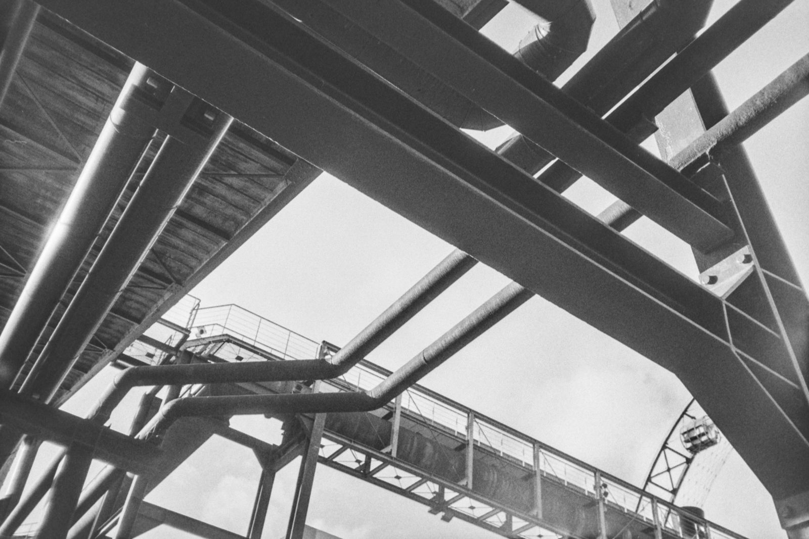 Intersection of industrial pipes and structural lines.