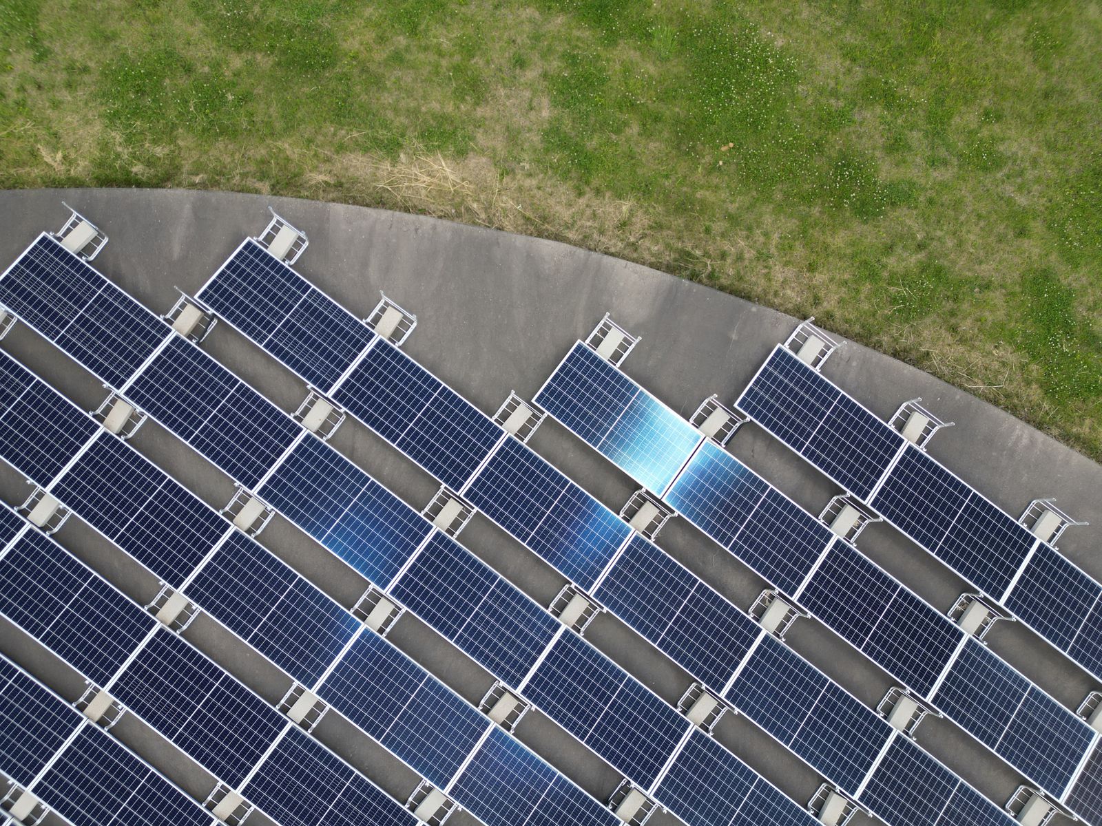 Aerial view of solar panels on a green field.